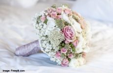 closeup-shot-bridal-bouquet-white-sheet-with-white-pink-green-colors_181624-24820